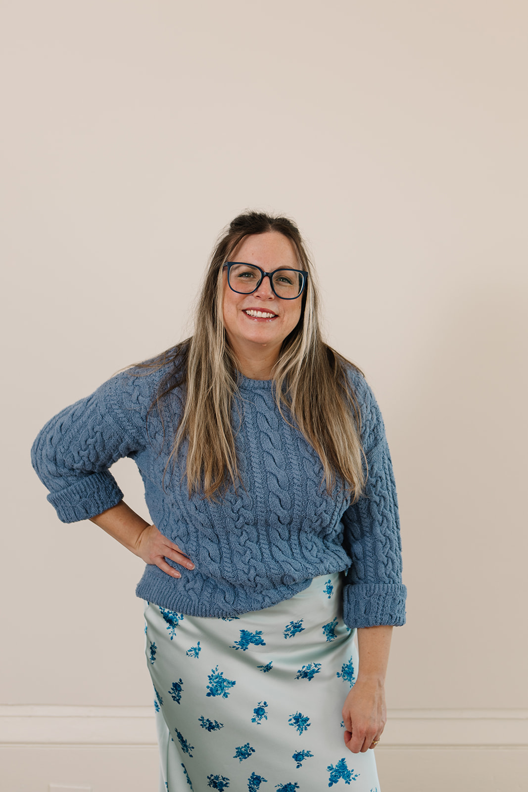 woman standing with hand on hip smiling
