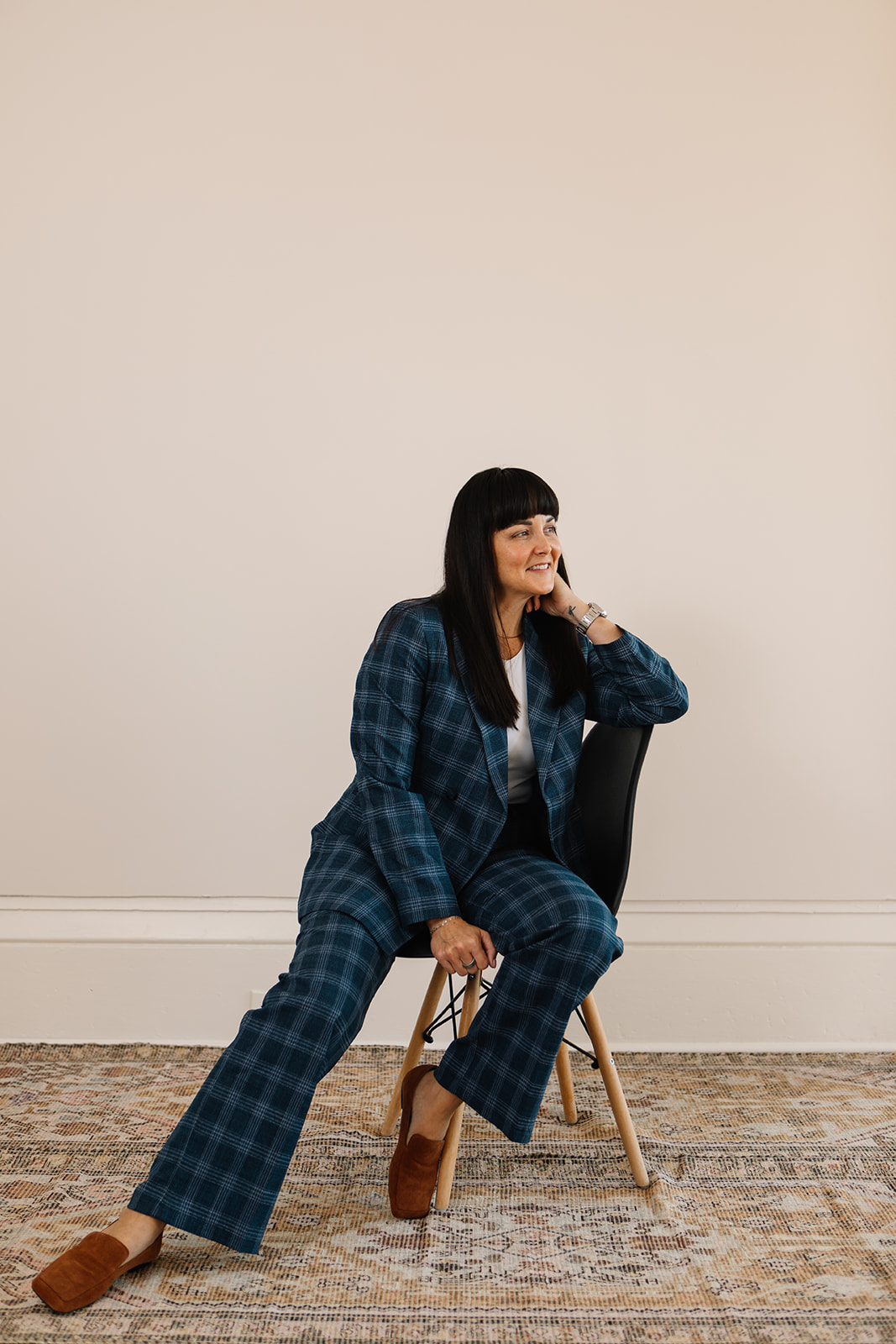 woman and real estate agent sitting on a chair with a smile
